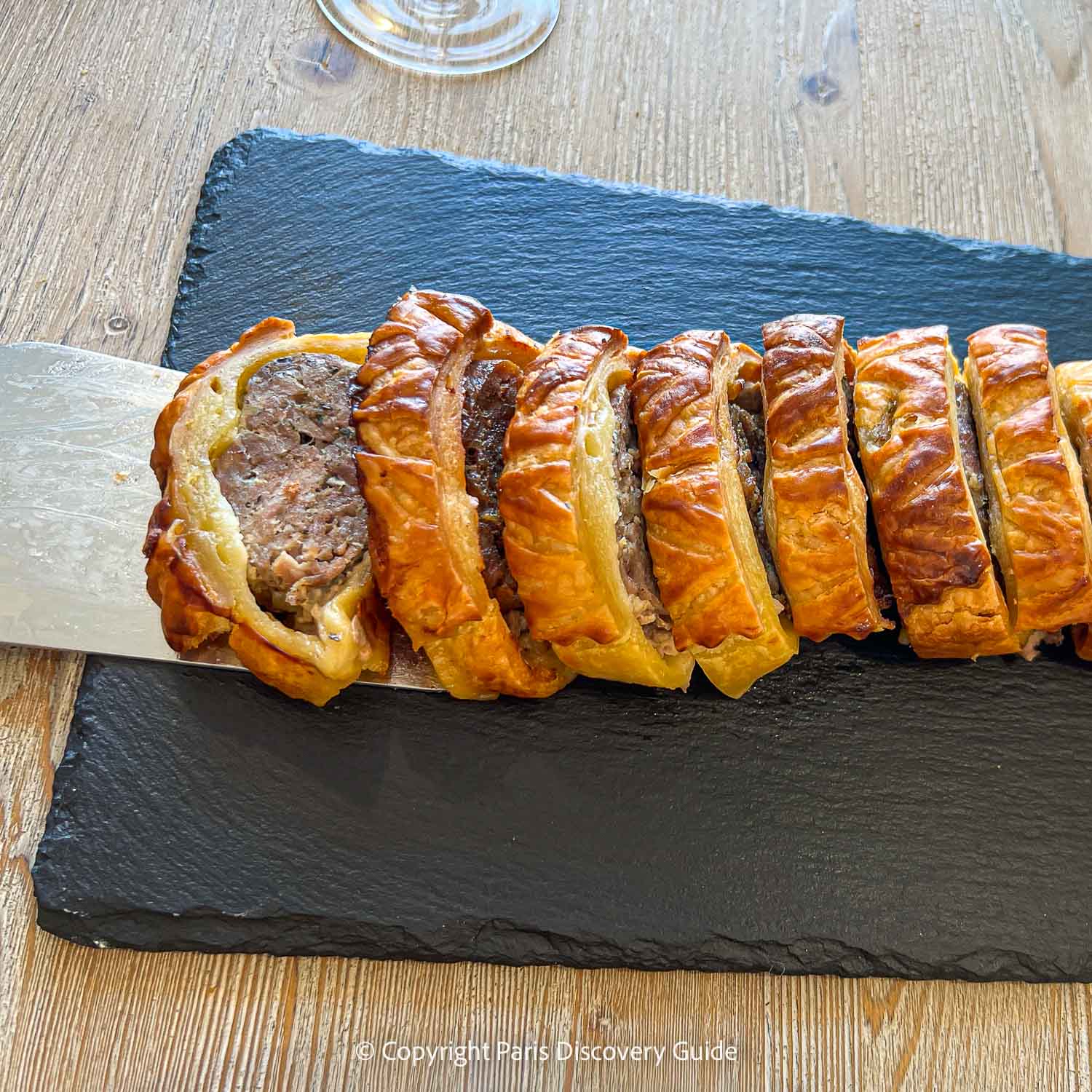 Savory sausage roll wrapped in puff pastry served as a first course during a Champagne wine tasting tour