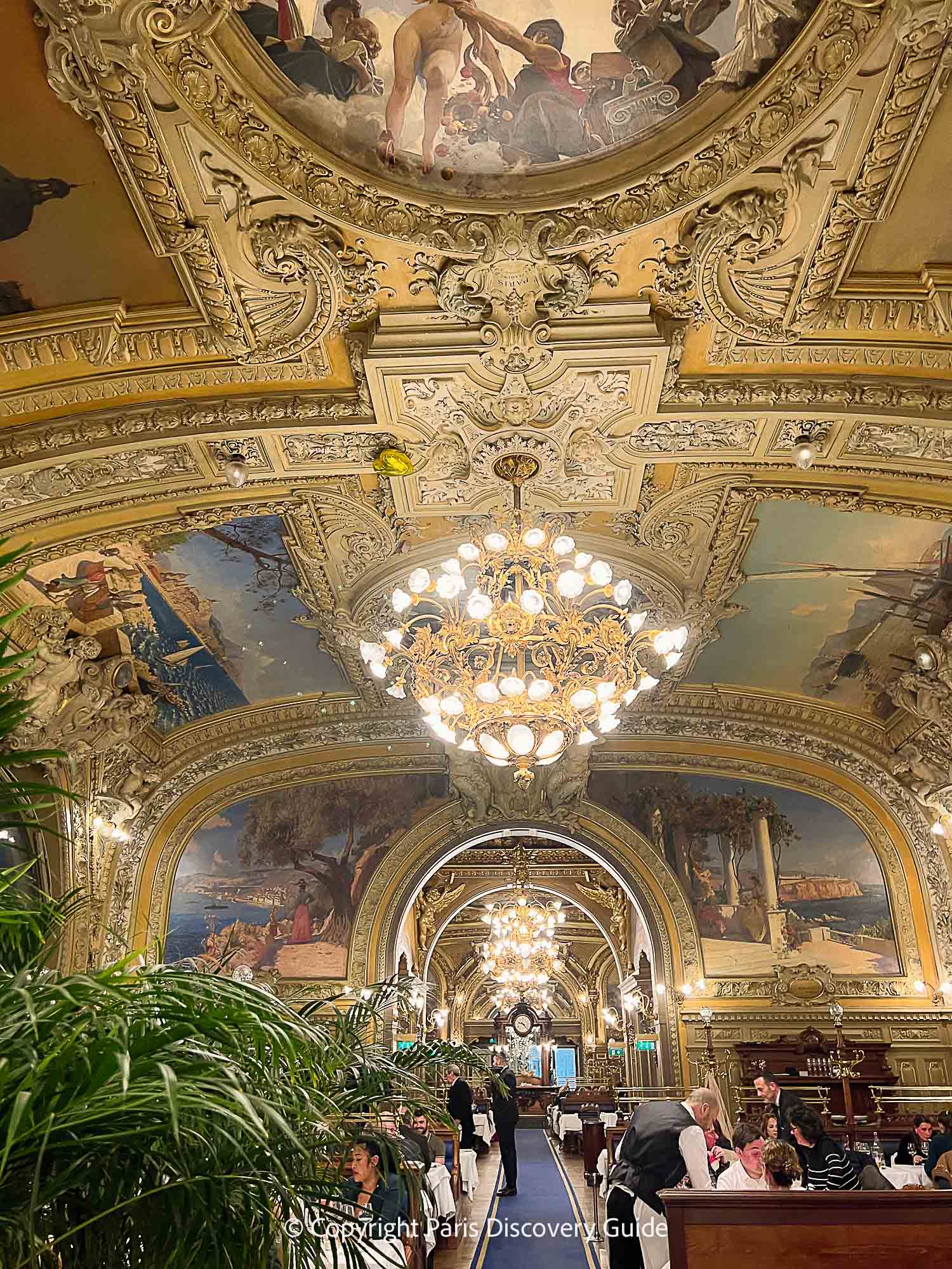 The soaring ceilings and painted frescoes at Le Train Bleu 