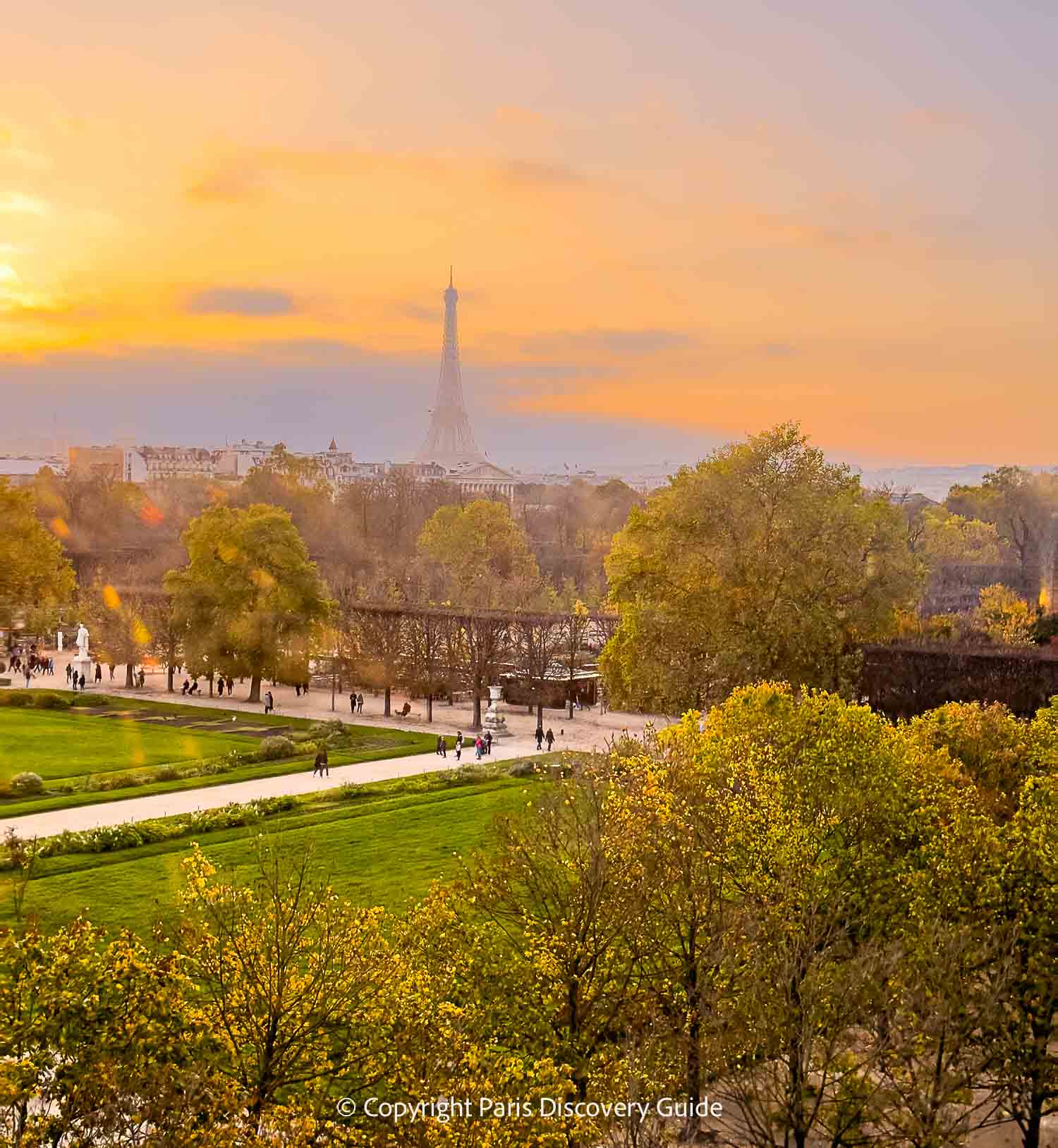 Sunset, the Eiffel Tower, and golden foliage in Tuileries Garden photographed from on top of the Marché de Noel Christmas Market