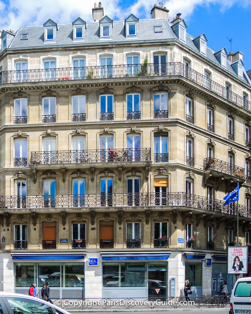 Woman using ATM machine (lower right corner) at LCL on Place Maubert in Paris's Latin Quarter