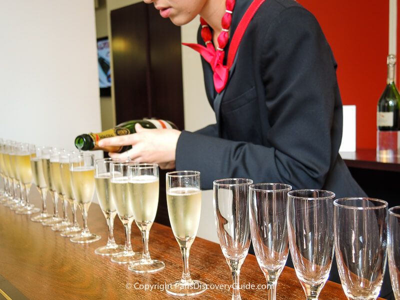 Champagne being poured for tasting in Mumm Champagne House's tasting room for a Paris day trip tour group Champagne being poured for tasting in Mumm Champagne House's tasting room for a Paris day trip tour group