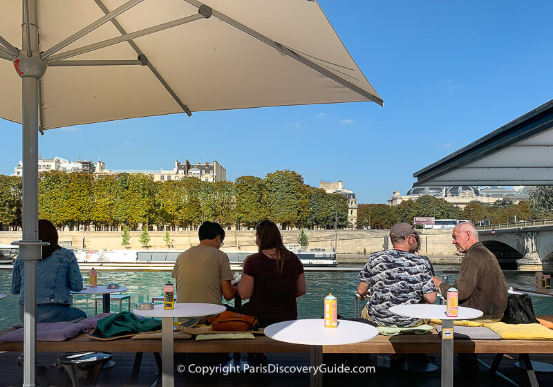 Seine-side terrace at Fluctuart, floating art gallery in 7th arrondissement