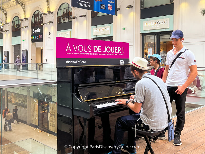 Man playing Mozart on the piano on Gare Saint-Lazare's top floor Man playing Mozart on the piano on Gare Saint-Lazare's top floor