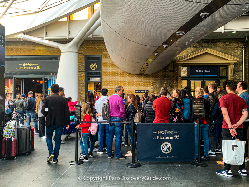 Harry Potter fans wait in line to take photos at Platform 9 3/4 in King's Cross Station