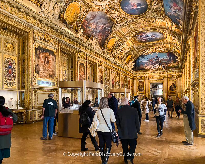 Does this winged man carrying a scythe painted on a ceiling near the Louvre's Apollo Gallery represent Zeus, Greek god of the sky, lightning, and thunder? Does this winged man carrying a scythe painted on a ceiling near the Louvre's Apollo Gallery represent Zeus, Greek god of the sky, lightning, and thunder?