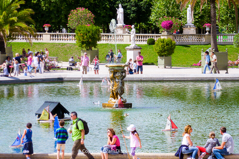 Children "sailing" wooden boats in Luxembourg Garden Children "sailing" wooden boats in Luxembourg Garden