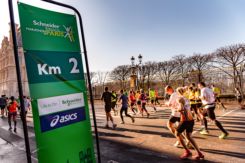 Paris Marathon runners pass the 2km sign in front of Tuileries Garden - Photo credit: istockphoto.com/onickzartworks