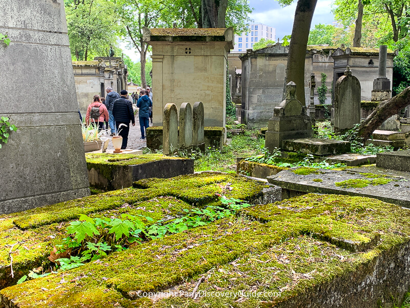 Moss-covered graves at Pere Lachaise Cemetery