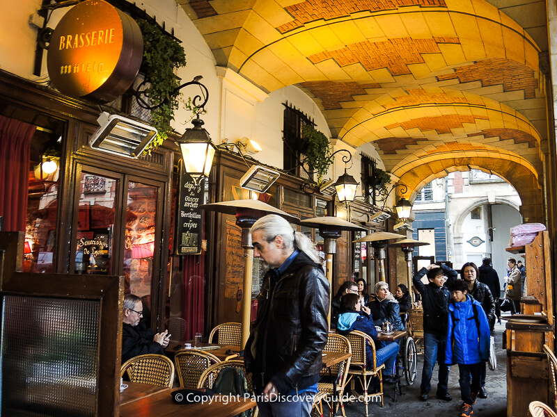Cozy bistro under the arcade surrounding Place des Vosges garden in the Marais Cozy bistro under the arcade surrounding Place des Vosges garden in the Marais