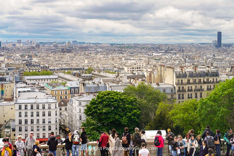 Sacre Coeur visitors on the terrace overlooking the Paris skyline