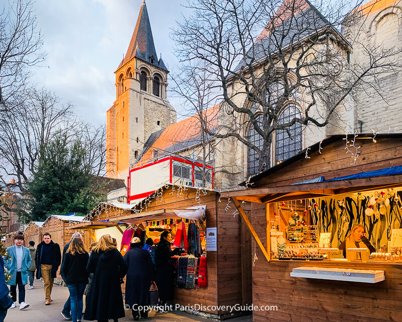 Chalets at the Saint-Germain-des Prés Christmas Market selling high-quality wool and cashmere scarves and hand-crafted jewelry
