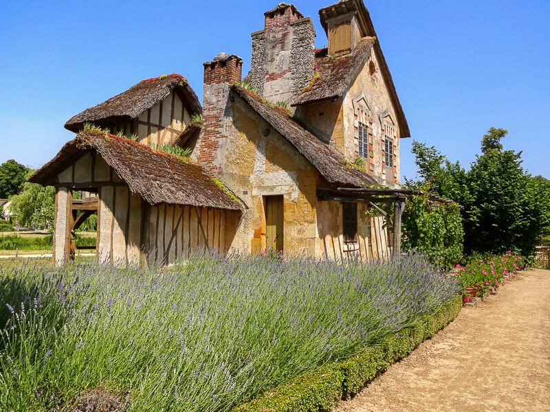 The rustic Flemish-style mill house (the mill wheel is on the other side) and lavender garden in Marie Antoinette's Hamlet in the park of the Château de Versailles - Photo credit: Alexandre Breveglieri