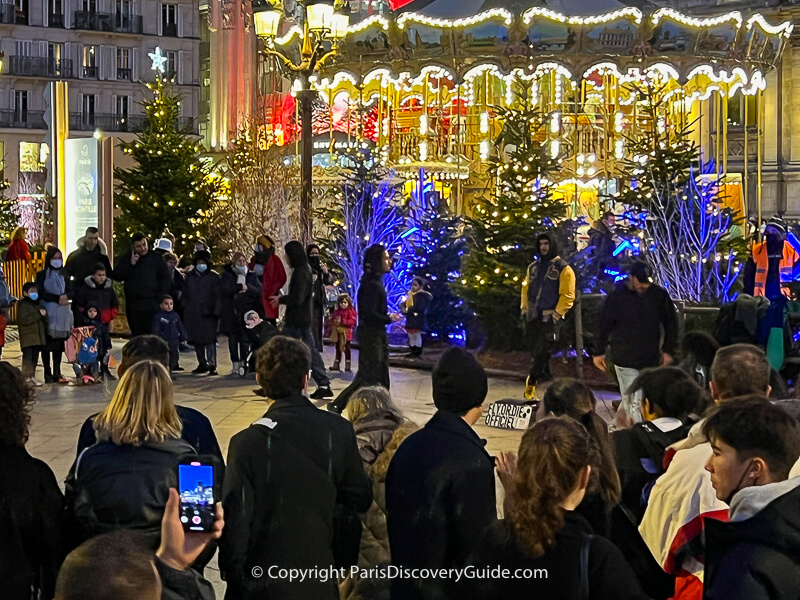 Performers in front of the carousel at Hotel de Ville Christmas Market
