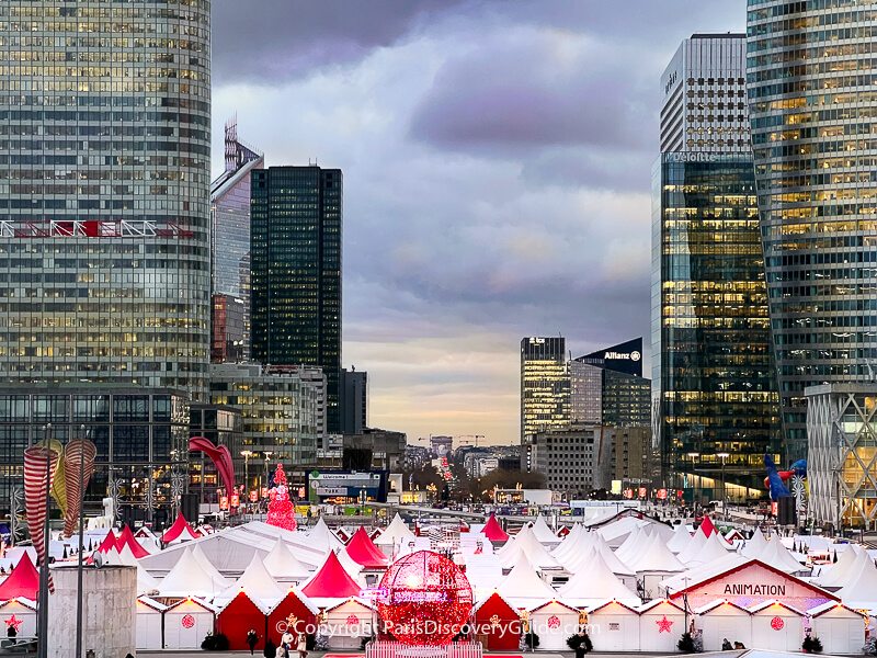 La Defense Christmas Market, skyscrapers, & distant view of Arc de Triomphe from the Grande Arche plaza