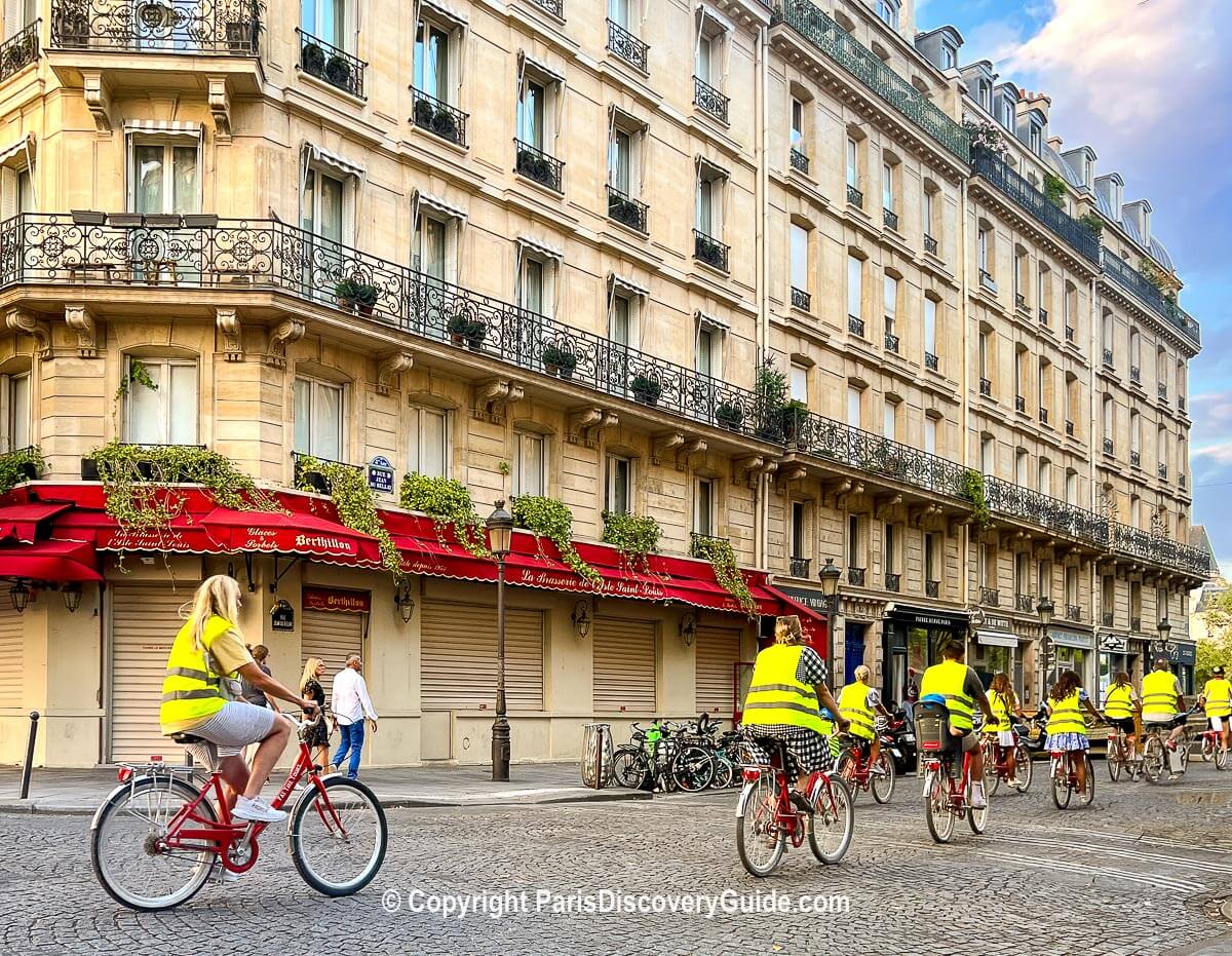 Paris bike tour participants wearing yellow vests on Ile Saint-Louis