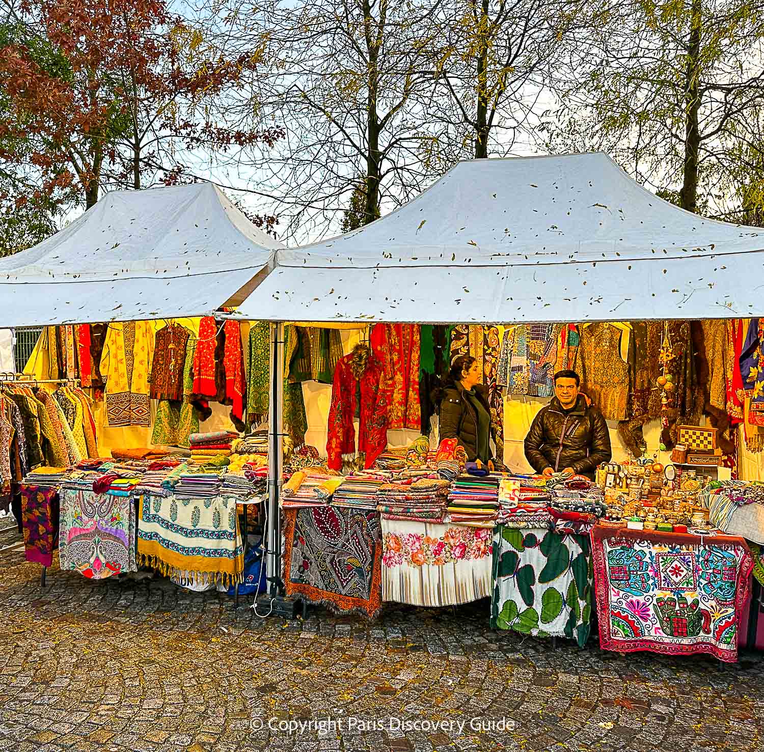 Les Halles Christmas Market chalet featuring clothing and decorative items from Tibet
