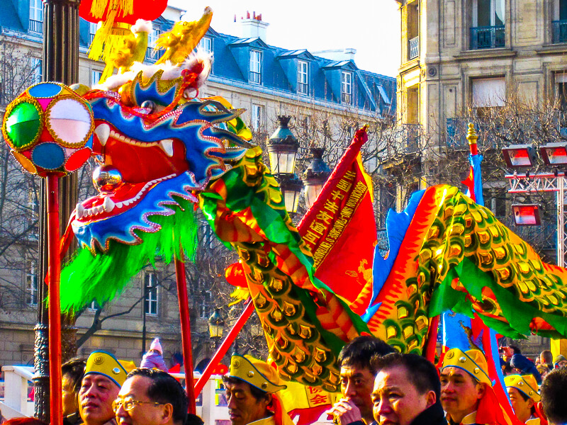 Marchers carrying flags in Paris Chinese New Year Parade