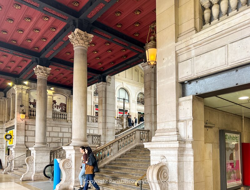 Metro station entrance and suitcase sculpture in Cour de Rome plaza in front of Gare Saint-Lazare