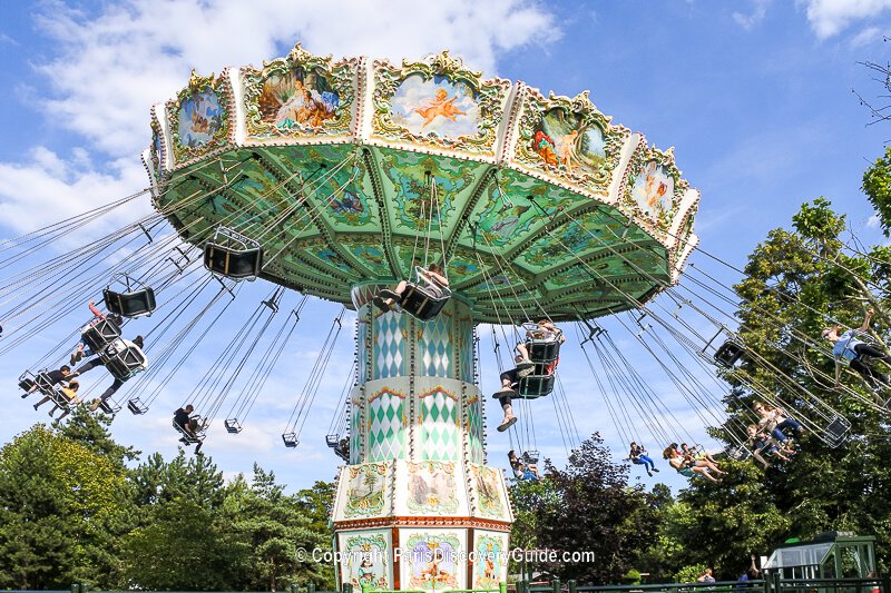 Kids, teens, & adults enjoying a ride at Jardin d'Acclimatation's amusement park next to Fondation Louis Vuitton