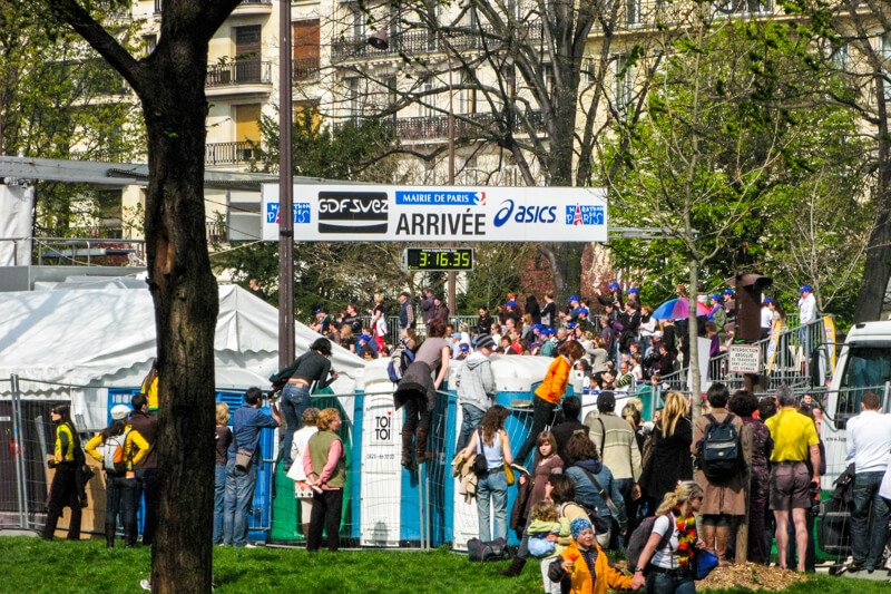 Spectators waiting behind barriers (and port-a-potties) at the Paris Marathon Finish Line