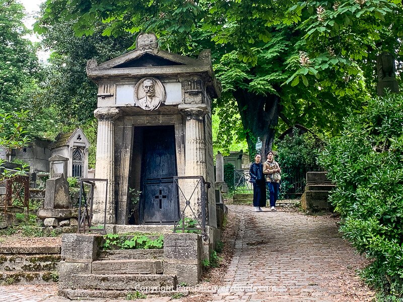 Couple walking along path at Pere Lachaise Cemetery