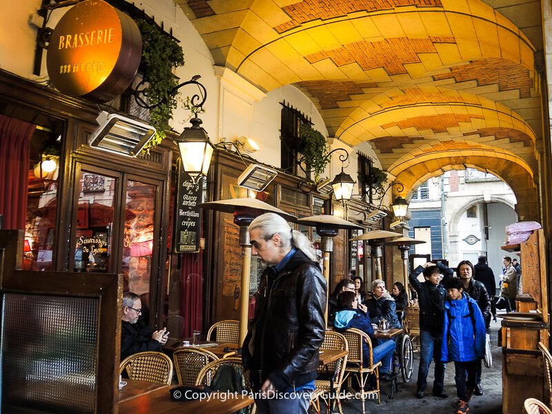 Cozy bistro under the arcade surrounding Place des Vosges garden in the Marais