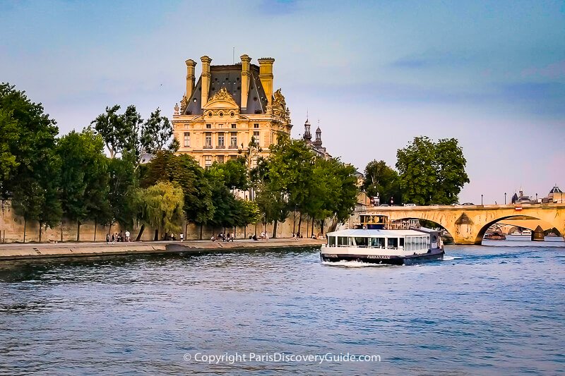 Seine River cruise boat heading toward Pont Royal bridge