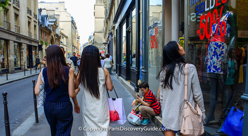 Soldes (sales) signs for 50% off in boutiques along rue de Franc Bourgeois in the Marais neighborhood in Paris Soldes (sales) signs for 50% off in boutiques along rue de Franc Bourgeois in the Marais neighborhood in Paris