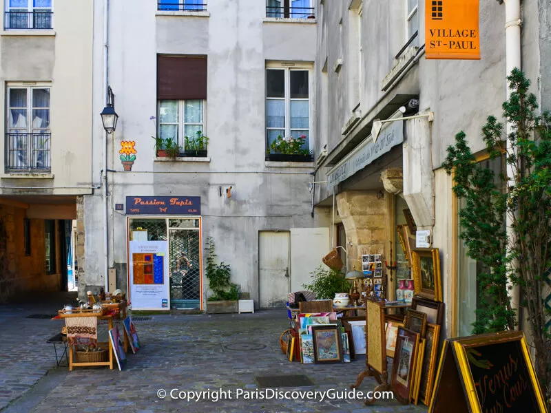 Shops featuring rugs and 19th and 20th century antiques in Village Saint-Paul in Paris
