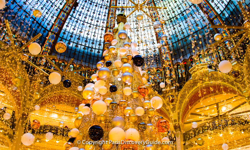 Christmas decorations and lights suspsended from the skylight dome in Galeries Lafayette Christmas decorations and lights suspsended from the skylight dome in Galeries Lafayette