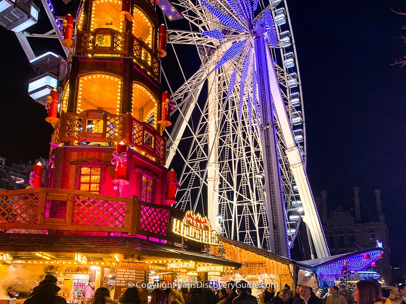 Crowds waiting to get a plate of raclette, the delicious melted cheese dish, next to the ferris wheel at the Tuileries Christmas Market